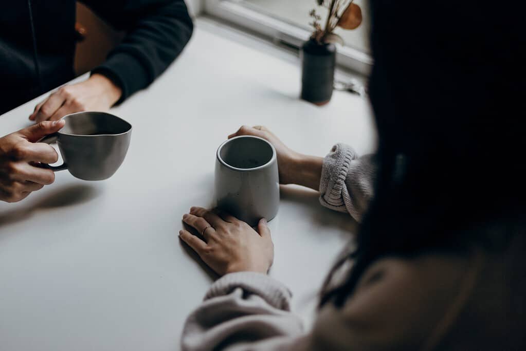 These two friends are enjoying a cup of coffee while having meaningful French conversation dialogue. Learning new phrases and exploring cultural aspects of the language in an inviting and relaxed atmosphere is the perfect way to enhance language skills!