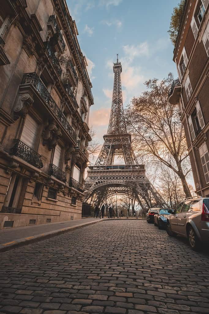 The iconic Eiffel Tower stands majestically in the middle of Rue de la Universite, a prime example of the beautiful French architecture that awaits you when you practice your French conversation phrases.