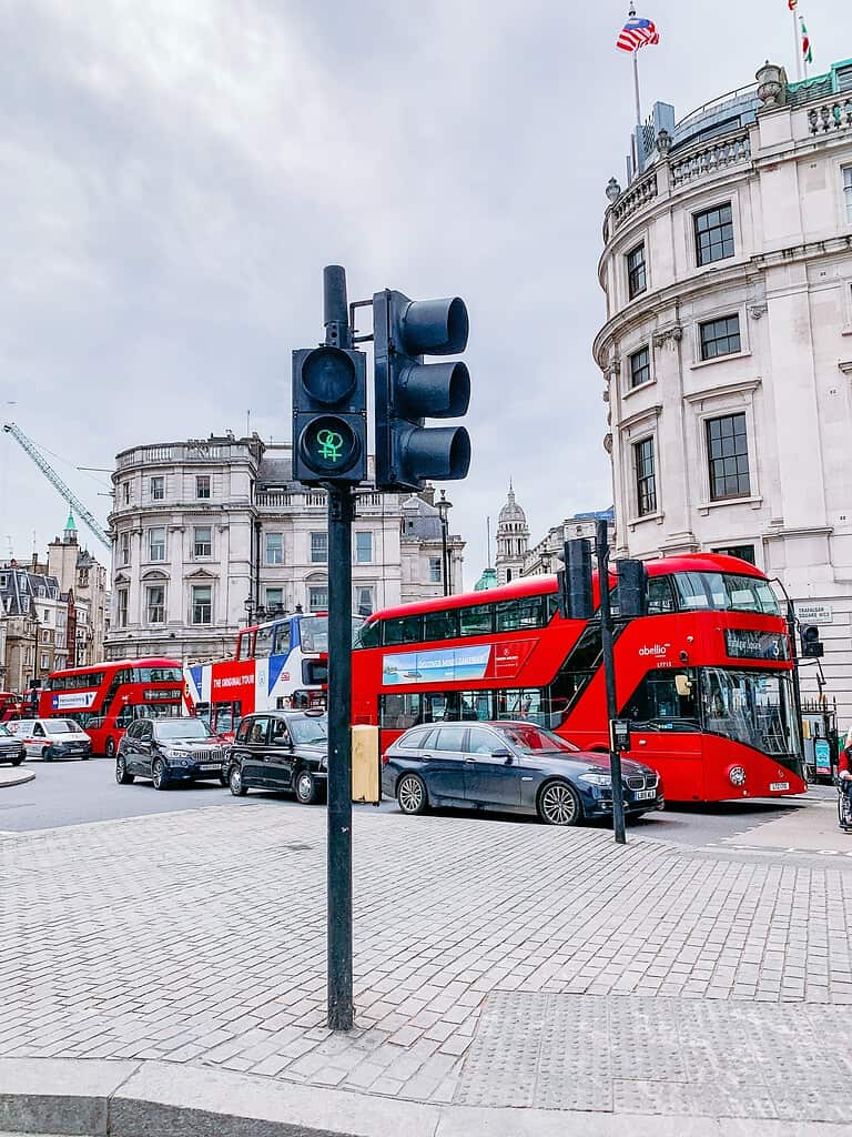 Trois bus rouges de Londres coincés dans la circulation, un parfait symbole de la conversation anglais français – parfois fluide, parfois bloquée. N'abandonnez pas, continuez à pratiquer avec swaplang.