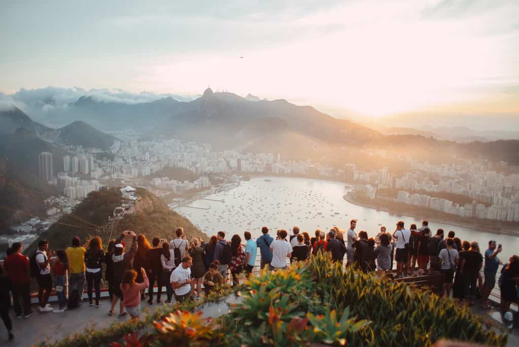 Groupe de touristes profitant de la vue imprenable sur Rio de Janeiro, améliorant leur expérience de voyage grâce à la conversation anglais tourisme.