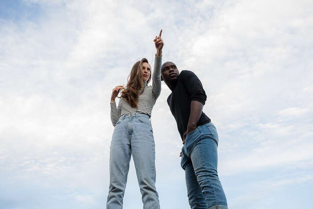Une femme indiquant la direction à un homme, illustrant un exemple de dialogue anglais pour demander son chemin.